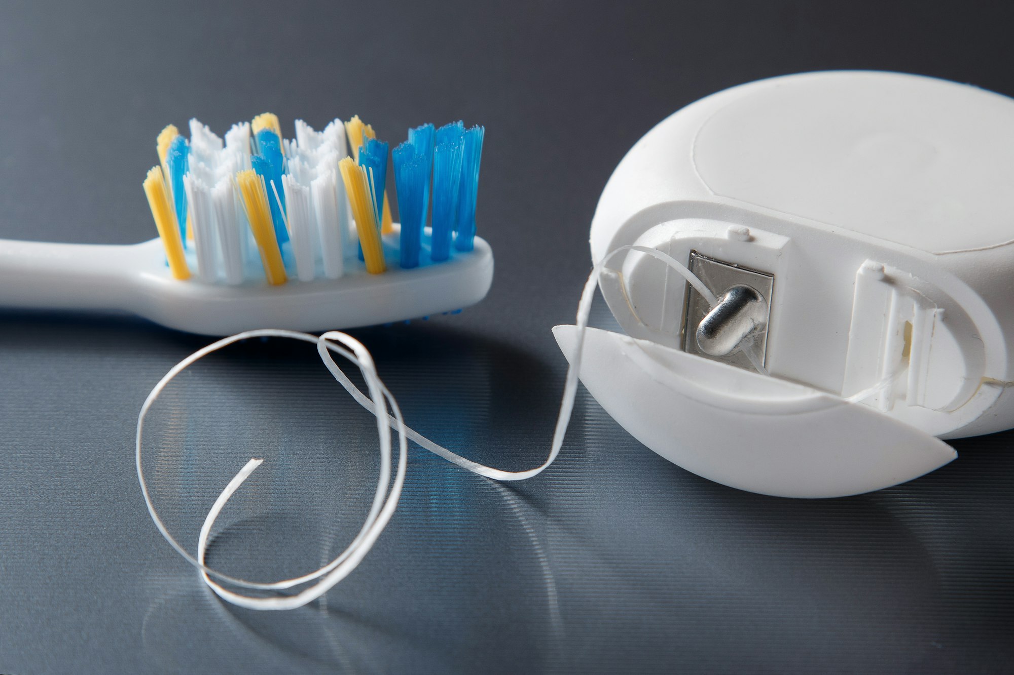 Essential dental care tools including toothbrush and floss, perfect for maintaining the longevity of dental implants at Dalin Dental Associates.